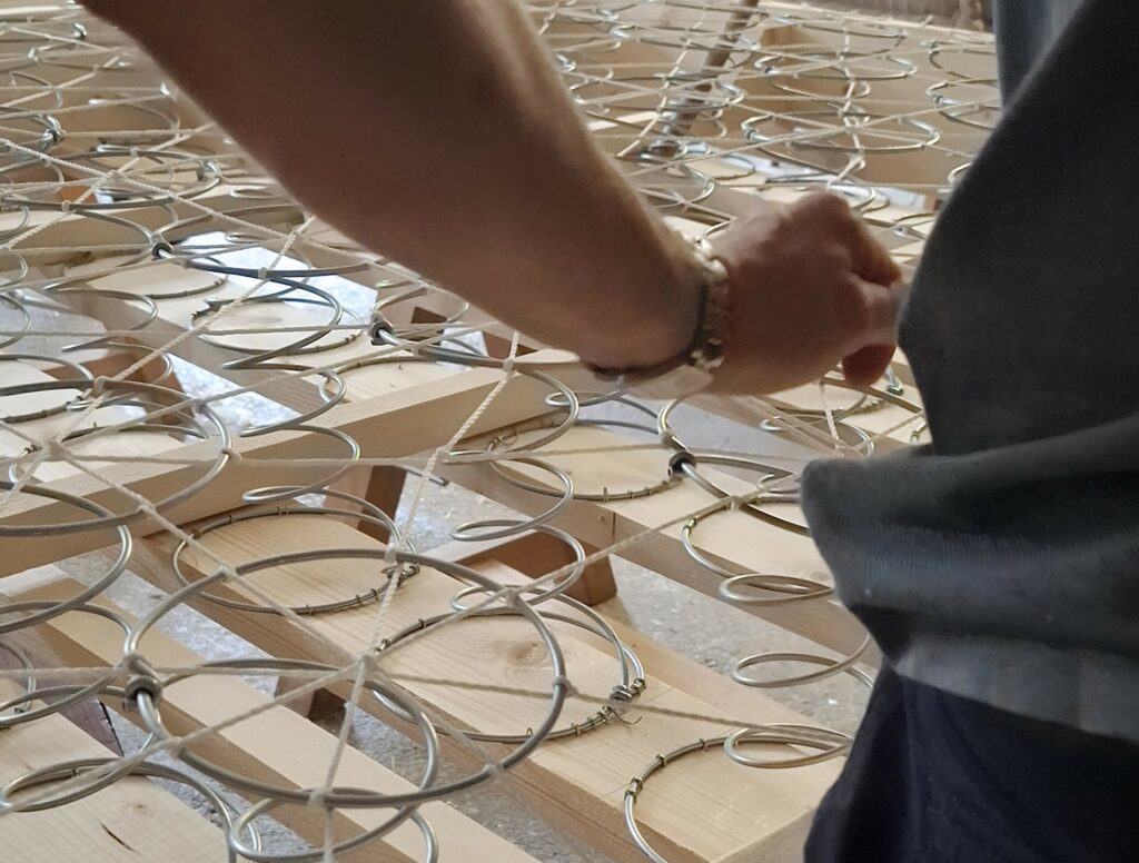 Guindage à la main en 8 d'un sommier à ressorts, fabrication artisanale Cardelaine