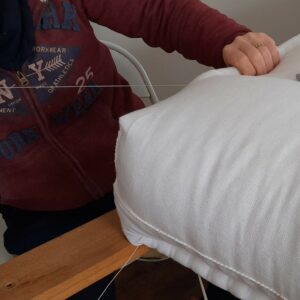 Couture manuelle pour faire les bourrelets du matelas en laine naturelle - Cardelaine
